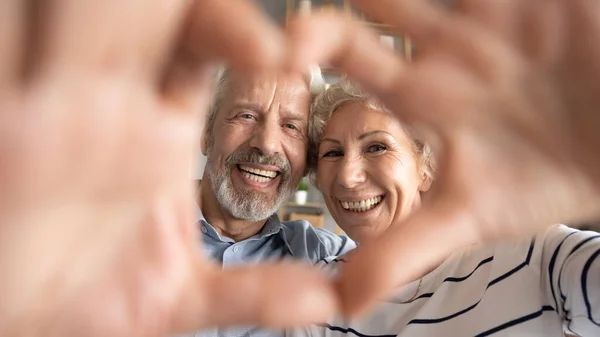 Gelukkige oudere gepensioneerde oudere familie koppel maken hart gebaar. — Stockfoto