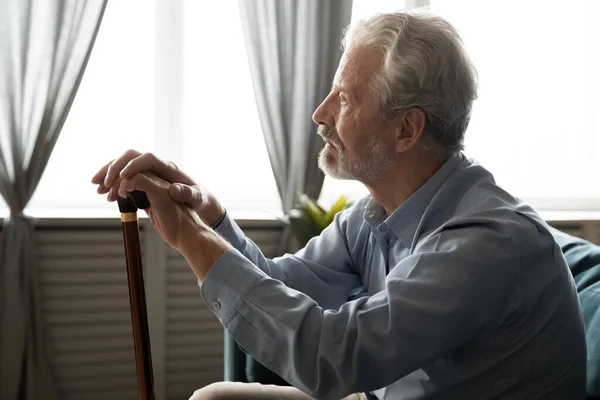 Pensive gestresste middelbare leeftijd gehandicapte oude man zittend op de bank. — Stockfoto