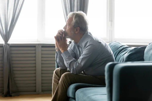 Несчастный дедушка средних лет потерялся в мыслях в одиночестве дома. — стоковое фото