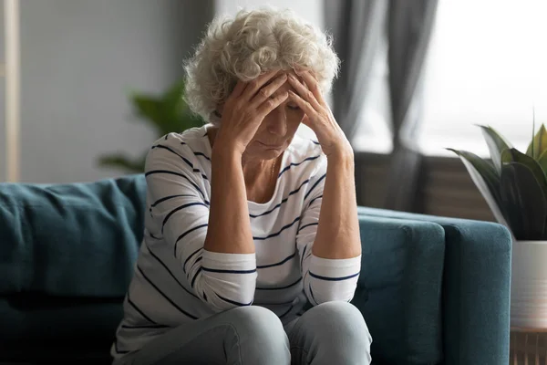 Unhealthy old senior retired woman suffering from strong headache. — Stock Photo, Image