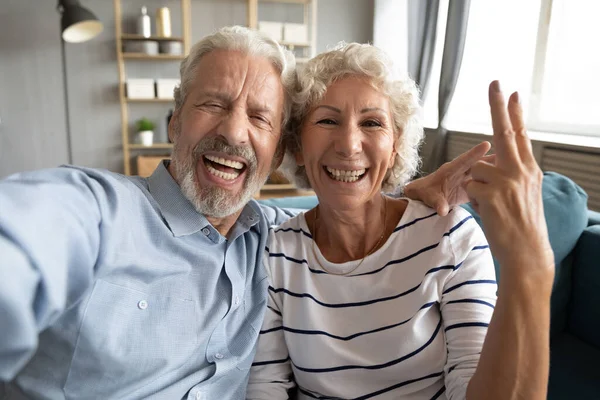 Overblij oprecht lachen middelbare leeftijd paar met video call. — Stockfoto