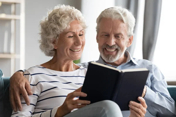 Feliz vínculo anciano jubilado familia jubilada pareja leyendo libro de papel. — Foto de Stock