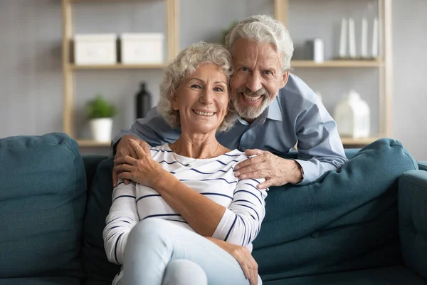 Cariñoso cuidado de mediana edad hombre abrazo sonriente esposa. —  Fotos de Stock