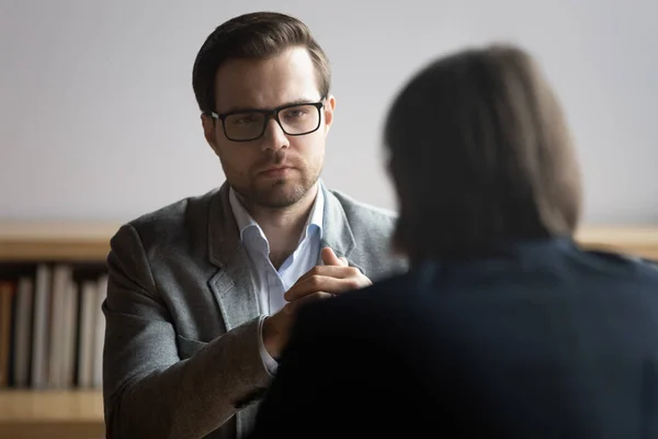 Geconcentreerde mannelijke hr manager in glazen luisteren naar sollicitant. — Stockfoto