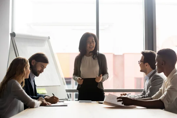 Happy mature korean asian female leader holding negotiations meeting. — Stock Photo, Image