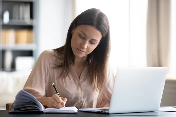 Close-up zelfverzekerde vrouw schrijven notities, zitten aan het werk bureau — Stockfoto