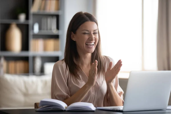 Радостная женщина смотрит на экран ноутбука, удивленная хорошими новостями — стоковое фото
