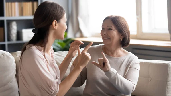Close up mature mother and grownup daughter speaking sign language — Stock Photo, Image