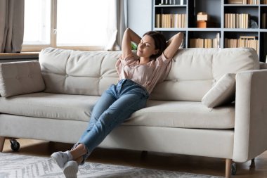 Uzun, sakin bir kadın. Gözleri kapalı, kanepede dinleniyor.