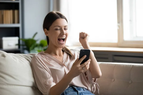 Chiudi la donna felicissima che tiene il telefono, urlando di gioia — Foto Stock