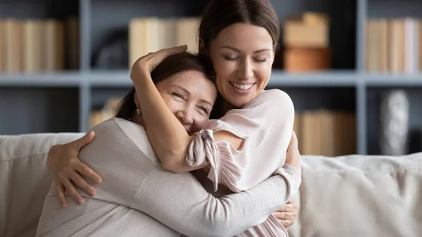 Fechar sorrindo jovem mulher abraçando mãe madura, expressando amor — Fotografia de Stock