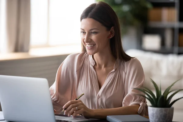 Närbild leende kvinna bär trådlösa hörlurar med bärbar dator — Stockfoto