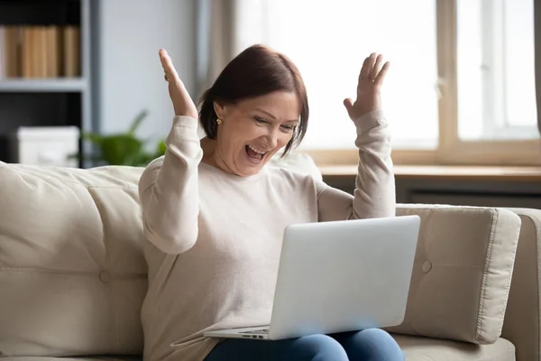 Laptop ekranına bakan aşırı neşeli olgun kadını kapat. — Stok fotoğraf