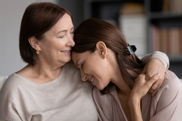 De cerca sonriente joven mujer y madura madre abrazando — Foto de Stock