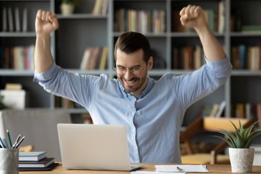 Gözlüklü genç adam çevrimiçi piyangoyu kutluyor..