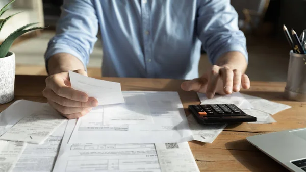 Jovem homem qualificado analisando contas de utilidades domésticas ou impostos. — Fotografia de Stock