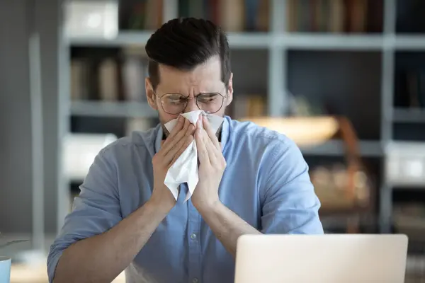 季節のアレルギーに苦しんでいる病気の千年の不幸なビジネスマン. — ストック写真