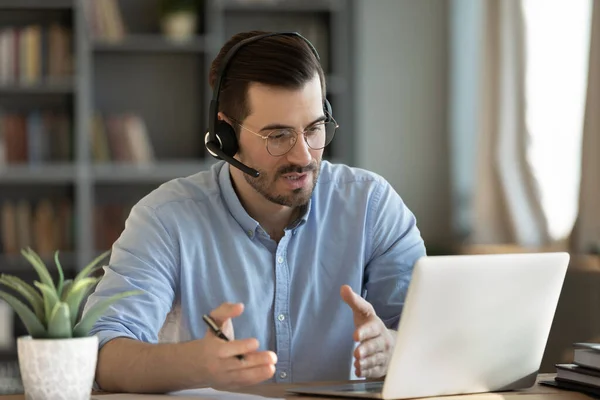 Geconcentreerde geschoolde duizendjarige Kaukasische zakenman houden van onderhandelingen vergadering online. — Stockfoto