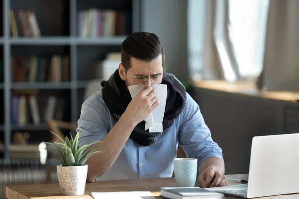 Unhealthy ill stressed young 30s businessman having first flu symptoms.