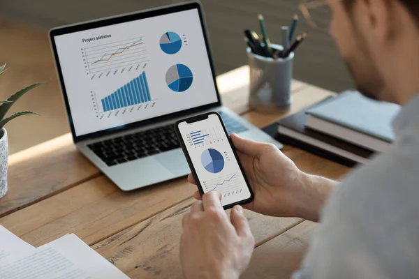 Joven empresario enfocado analizando los resultados de la investigación de marketing en gadgets. — Foto de Stock