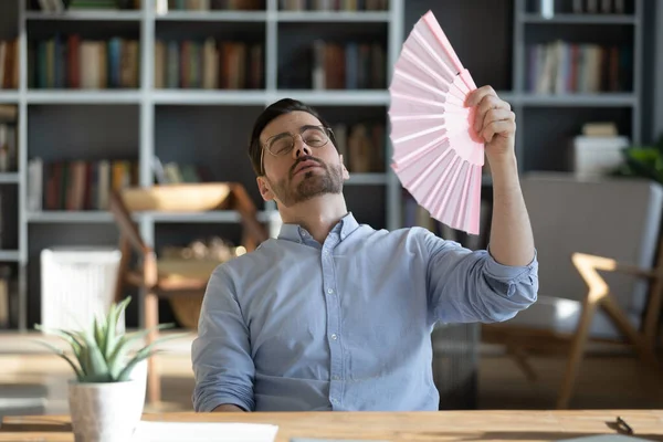 Stressed exhausted young 30s businessman using paper fan. — Stock Photo, Image