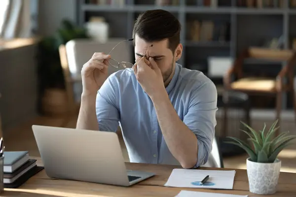 Insalubre millennial estresado hombre de negocios quitándose las gafas —  Fotos de Stock