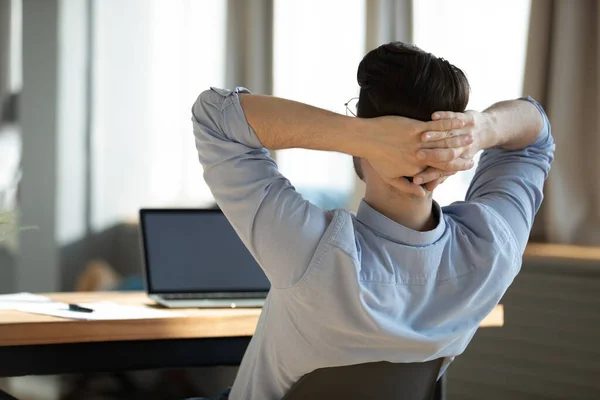 Gelukkig jong mannelijk werknemer rusten op stoel tijdens de werkdag. — Stockfoto