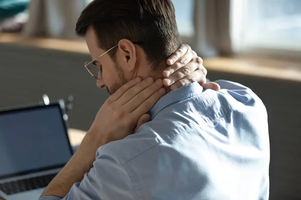 Joven estresado poco saludable que sufre de sentimientos dolorosos en el cuello. — Foto de Stock