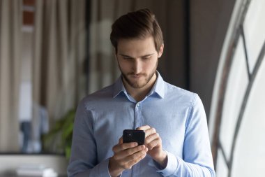 Telefon ekranına bakan ciddi bir iş adamını kapat.