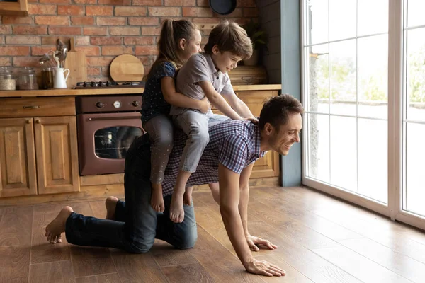 幸せな子供たちは家で若いお父さんと遊ぶ — ストック写真