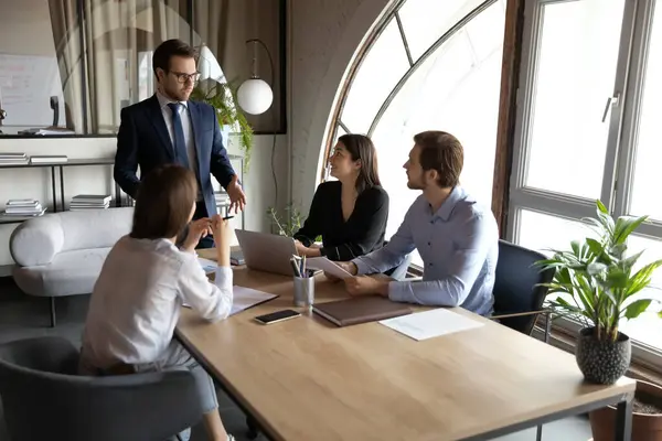 Diversos empleados escuchan a mentor coach en reunión corporativa — Foto de Stock