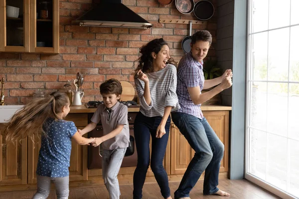子供たちと一緒に楽しい若い家族がキッチンで踊る — ストック写真