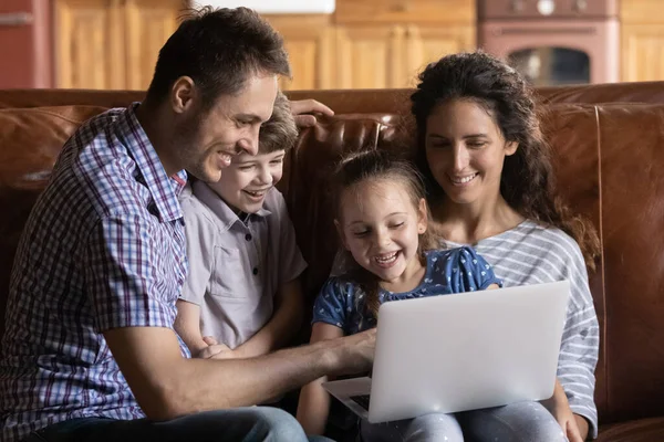 Famille ravie avec les enfants regarder la vidéo sur ordinateur portable — Photo