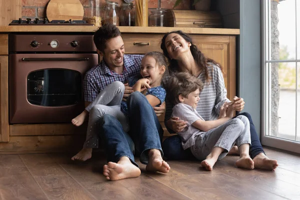 Überglückliche Eltern haben Spaß beim Spielen mit kleinen Kindern — Stockfoto