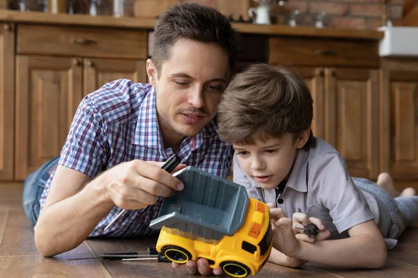 愛するお父さんは小さな息子と車を修復する楽しみを持っています — ストック写真