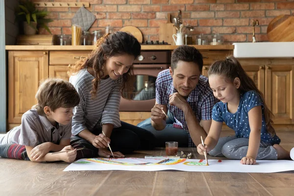 Des parents heureux avec de petits enfants qui dessinent ensemble — Photo