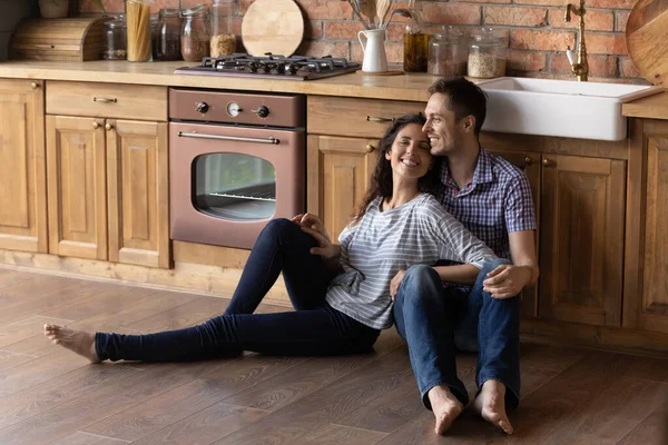 Sorrindo casal milenar relaxar na própria cozinha casa — Fotografia de Stock