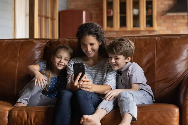 Mamma felice e bambini piccoli guardare video sul cellulare — Foto Stock