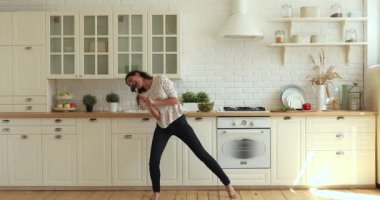 Genç güzel bayan mutfakta yemek hazırlarken eğleniyor..