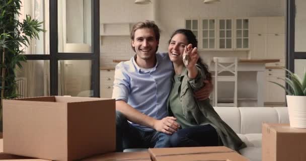 Smiling millennial bonding family couple showing keys to camera. — Stock Video