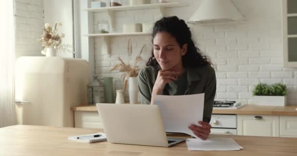 Gelukkige jonge zakenvrouw analyseren papieren documenten, werken op de computer. — Stockvideo