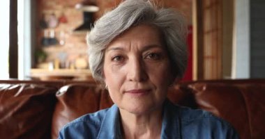 Portre mutlu yaşlı kadın parmaklarını birleştirerek kalp sembolü yapıyor.