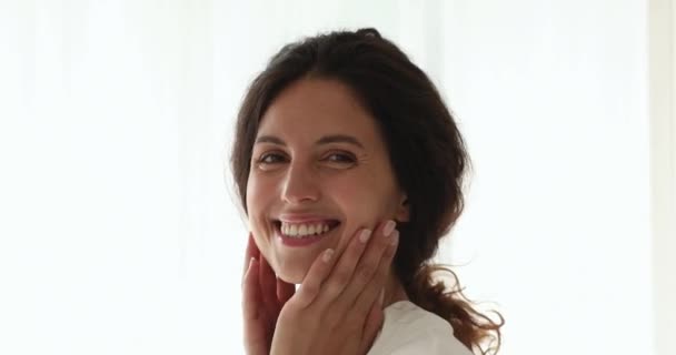 Sorrindo jovem mulher europeia bonita fazendo massagem facial. — Vídeo de Stock