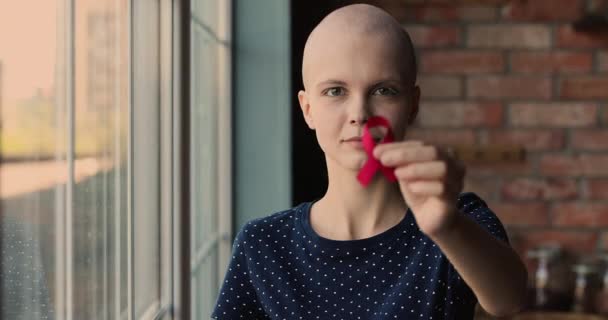 Careca paciente câncer feminino segurando fita vermelha vista close-up — Vídeo de Stock