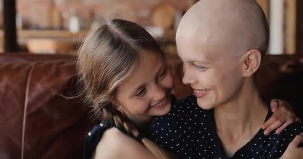 Close up happy little daughter huggs mother cancer patient — Stock video