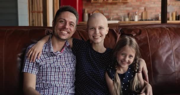 Glücklicher Ehemann, kleine Tochter umarmt lächelnde Krebspatientin — Stockvideo