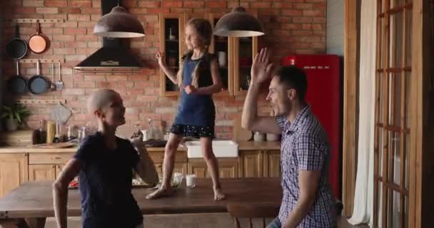 Familia feliz con hija pequeña bailando en la cocina — Vídeos de Stock