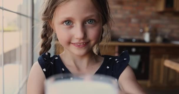 Close up little girl holding glass drinks milk — Stock Video