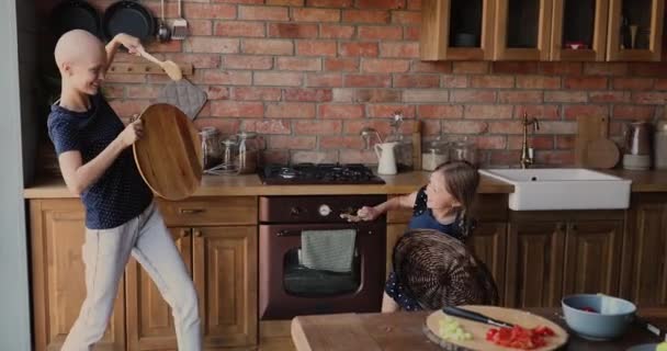 Glückliche kleine Tochter spielt mit Mutter Krebspatientin in Küche — Stockvideo