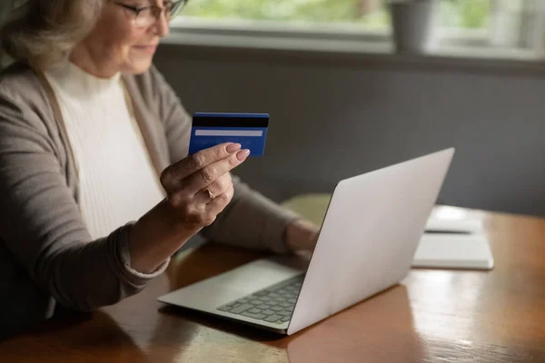 Close up mature woman making internet payment, holding plastic card — Stock Photo, Image